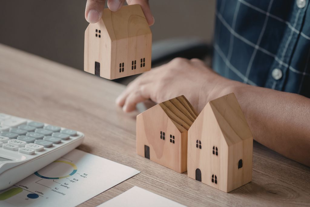 Model houses on a desk representing common risks for property owners